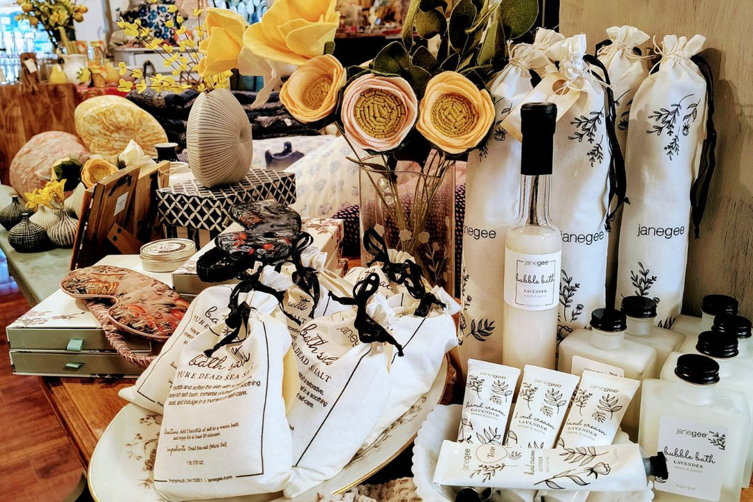 Curated display of janegee bath and body products, gift sets, and accessories arranged with florals and home decor in a boutique setting
