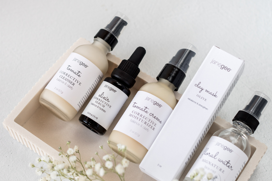 5 janegee products on a marble tray with flowers