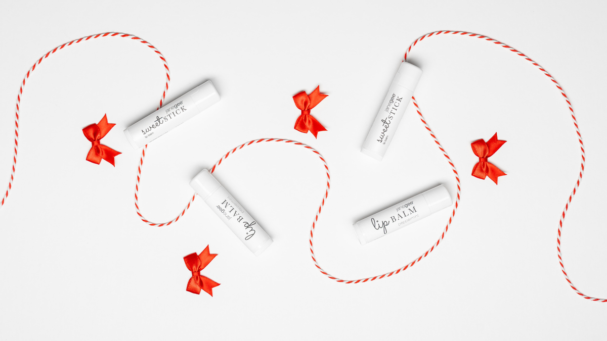 Four janegee Sweet Sticks arranged with red-and-white cord and small red bows on a white background.