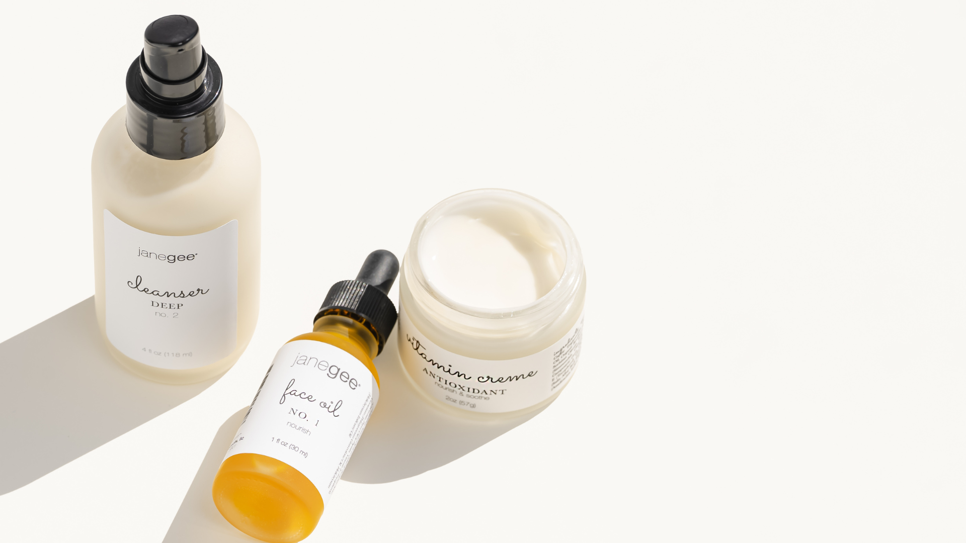 Set of skincare products including a bottle, dropper, and jar on a white background